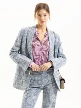 Blazer de algodón azul con bordado floral en color crudo, solapas clásicas, bolsillos delanteros con tapa y largo hasta la cadera.