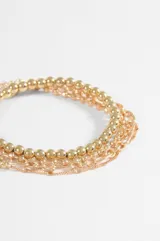 Set de cuatro pulseras de cadena en tono plateado con diferentes diseños, incluyendo una de esferas pequeñas, una de eslabones tipo figaro, una de cadena fina con pequeñas cuentas y una cadena delgada con detalles espaciados.