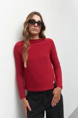 Remera negra de manga larga, cuello alto y corte diagonal en la parte inferior.