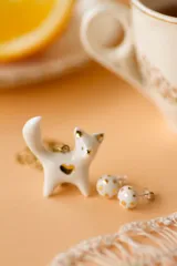 Aros tipo broquel de porcelana blanca con diseño de lunares en lustre de oro. Piezas artesanales horneadas a alta temperatura con detalles en oro.