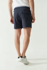 Short de baño liso de corte clásico, con cintura elástica ajustable mediante cordón. Cuenta con dos bolsillos laterales y uno trasero, confeccionado en tejido ligero de secado rápido con logo bordado.