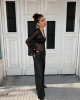 Body de tul transparente color negro, de manga larga con terminación acampanada y detalles de encaje en el escote en V y en los puños.