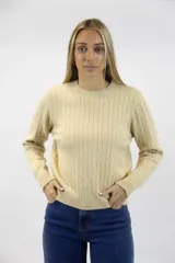 Sweater de punto color beige con diseño de ochos verticales, cuello redondo y mangas largas con terminaciones en rib.