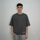 Remera gris de algodón, corte oversize, con mangas cortas y estampado en la espalda con la palabra 'nenefa' en cursiva blanca.