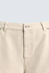 Pantalón relaxed fit color beige, confeccionado en tejido de algodón. Cuenta con bolsillos frontales, bolsillos traseros de plastrón y aplicación de bolsillos plastrón con tira multifunción en la pernera. Cierre frontal con cremallera y botón.