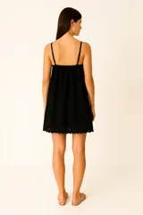 Vestido corto de algodón color blanco, con breteles finos regulables y escote en V profundo. Presenta detalles de broderie en el escote y en el ruedo, con un diseño de corte holgado tipo babydoll.