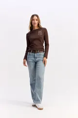 Remera de manga larga color marrón, con cuello redondo y estampa sutil en el pecho con diseño de juego de ta-te-ti y texto.