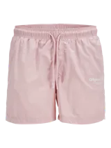 Short de baño color rosado, con cintura elástica y cordón ajustable. Presenta un diseño minimalista con un pequeño estampado gráfico en la pierna derecha.