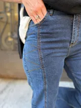 Pantalón de jean estilo wide leg con diseño de paneles y costuras visibles en contraste. Presenta un corte amplio y tiro alto, confeccionado en denim con elasticidad.