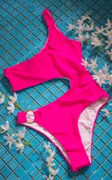 Traje de baño enterizo fucsia con un solo hombro y aro dorado en la cadera.