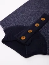 Buzo de punto color marrón oscuro con cuello alto y cierre frontal parcial de cuatro botones. Presenta una textura jaspeada y puños acanalados.