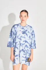 Sweater de punto tipo remerón oversize con diseño batik artesanal en tonos azul y blanco. Presenta silueta amplia, manga caída y etiqueta tejida con monograma en el frente.