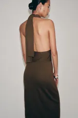 Vestido midi de punto color marrón, con diseño sin mangas, cuello halter cruzado y anudado, y espalda descubierta.