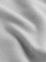 Sweater de punto liso color gris claro, con cuello redondo y manga larga. Presenta el logo de Calvin Klein Jeans bordado en blanco en el pecho.