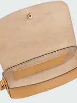 Cartera crossbody de cuero color tostado, con diseño de solapa redondeada, cierre de broche metálico y correa larga ajustable para llevar al hombro o cruzada.