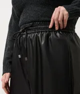 Pantalón de corte wide leg confeccionado en poliuretano con acabado liso que imita el cuero. Presenta cintura elástica con cordón de ajuste, bolsillos laterales embutidos y una silueta fluida y amplia.