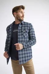 Sobrecamisa de viyela para hombre, de corte regular y manga larga. Presenta un diseño a cuadros en tonos azules y blancos, con cierre frontal de botones, bolsillos en el pecho y un interior capitoneado para mayor abrigo.