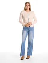 Chaqueta de punto color beige, con cuello redondo, cierre frontal mediante botones metálicos y bolsillos aplicados en la parte delantera.
