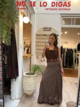 Pollera midi tipo pareo de satén color chocolate con estampado de lunares blancos. Presenta un diseño envolvente con ajuste lateral y un ruedo con detalle de microtul y puntilla bordada.