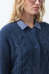 Cardigan de tejido de punto color marrón chocolate, con diseño de trenzas en el frente y mangas. Presenta cuello redondo, cierre frontal con botones al tono y puños acanalados.