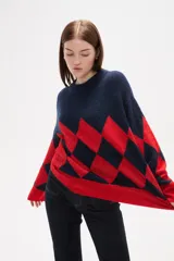 Sweater de tejido jacquard con diseño de rombos en colores azul marino y rojo, de corte holgado, manga larga y cuello redondo.