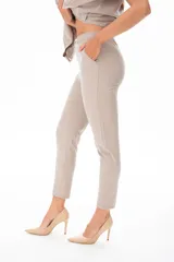 Pantalón de vestir color beige, con corte recto, bolsillos laterales y cinturón con hebilla metálica.