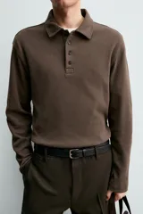 Polo de manga larga con corte regular fit, confeccionado en tejido de algodón con acabado cepillado. Presenta cuello solapa y cierre frontal con botonadura.