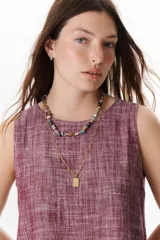 Top sin mangas de corte recto y holgado, confeccionado en tejido de lino con textura jaspeada en tono azul. Presenta cuello redondo y un diseño minimalista ideal para climas cálidos.