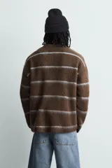 Jersey de punto con textura, corte relajado, cuello redondo y manga larga. Presenta un diseño de rayas horizontales en tonos marrones y grises con acabados en rib.