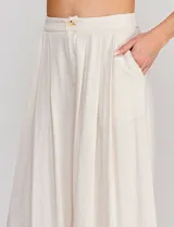 Pantalón palazzo de lino y viscosa, color blanco, de tiro alto y silueta amplia. Presenta pinzas frontales, bolsillos laterales y cierre con botón.