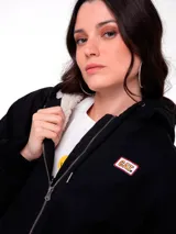 Chaqueta de lona color negro con forro interior de sherpa, cierre frontal con cremallera, capucha y puños elásticos.