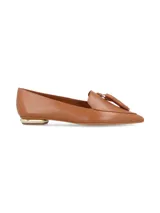 Zapato de cuero color caramelo, estilo mocasín con puntera fina y detalle de borla en el empeine. Cuenta con un tacón bajo con detalle metálico dorado.