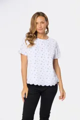 Blusa blanca con estampado floral negro, de corte recto y manga corta.
