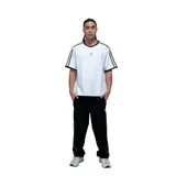 Remera unisex de corte holgado, color blanco con detalles en negro en el cuello y mangas. Presenta dos líneas verticales negras en cada manga y un pequeño logo bordado en el centro del pecho.