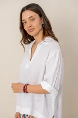 Blusa blanca de lino de manga larga con cuello en V y calce holgado.