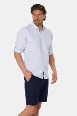 Bermuda clásica de lino color beige, de corte recto con bolsillos laterales y traseros ribeteados con botón.