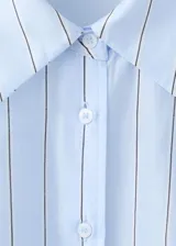 Camisa oversize de manga larga a rayas celestes y blancas, con cuello solapa camisero y cierre frontal de botones.