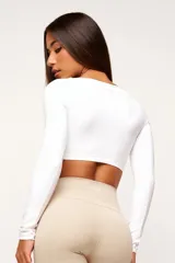 Top deportivo blanco de manga larga con escote cuadrado.