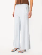 Pantalon de cuero de corte ancho y tiro medio, con cintura elástica y detalle de botones a presión en los laterales de las piernas.