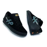 Championes urbanos Öus modelo Cuoro, color negro con detalles en azul y naranja. Presentan un diseño de perfil bajo con logo lateral distintivo y suela de goma texturizada.