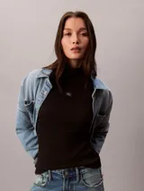 Top negro de manga larga con cuello tortuga, confeccionado en punto fino elástico de algodón BCI y lycra. Presenta un diseño ajustado de corte slim fit con un pequeño parche con el monograma de la marca en el centro del pecho.