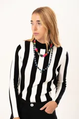 Polera de tejido de punto con diseño de rayas verticales anchas en blanco y negro, cuello alto y manga larga.