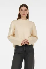 Sweater de viscosa color beige, con cuello polera, corte holgado y pespuntes decorativos en el frente.