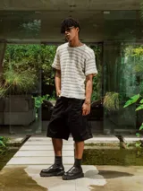 Remera de tejido de punto abierto, color crudo y beige, con diseño de rayas horizontales finas. Presenta cuello redondo y mangas cortas.