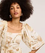 Vestido midi evasê de Marfinno, confeccionado en mezcla de viscosa y lino, con estampa de mapa en tonos beige y tostado sobre base off-white. Presenta escote cuadrado, mangas amplias con detalles bordados en los bordes y corte fruncido en la cintura.