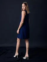 Vestido azul marino de seda fría, sin mangas y escote a la base con aplique de perlas.