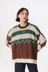 Buzo de tejido de punto con diseño geométrico y combinación de colores en contraste. Presenta cuello redondo, mangas largas y corte oversized.