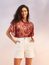 Camisa de manga corta con estampado de flores en tonos amarillo, negro y beige.