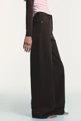 Jeans de tiro alto con diseño de pierna extra ancha y larga. Presenta cinco bolsillos, cierre frontal con cremallera y botón metálico, con un acabado de lavado desgastado.