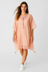 Túnica color salmón de algodón con bordado calado, corte holgado, escote en V con lazos y terminación con borlas.